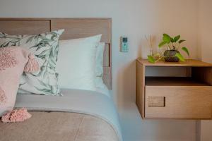 une chambre avec un lit avec une table de chevet en bois avec une plante dans l'établissement Condos with ocean view pool in Av 10 & 60 street, à Playa del Carmen 28 autres photos