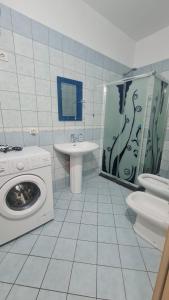 uma casa de banho com uma máquina de lavar roupa e um lavatório em Summer Home em Vlorë