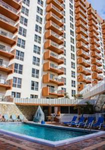 羅德岱堡的住宿－Ft Lauderdale Beach resort，一座带椅子的室外游泳池和一座大型建筑