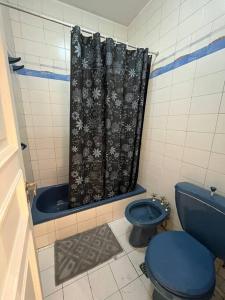 y baño con aseo azul y cortina de ducha. en Casa Chill en Mendoza