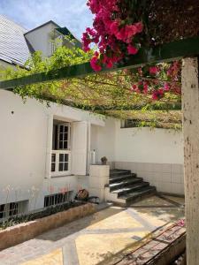 Uma casa branca com flores cor-de-rosa ao lado. em Casa Chill em Mendoza