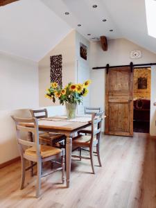 a dining room table with chairs and a vase of flowers at La Mansarde in Vernon