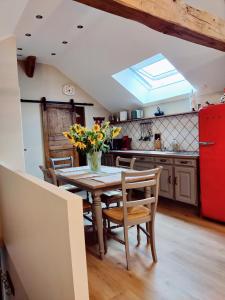 a kitchen with a table and chairs and a red refrigerator at La Mansarde in Vernon