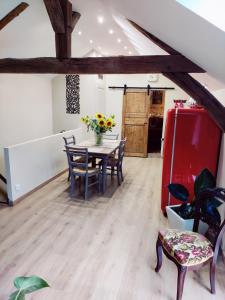 a dining room with a table and chairs and a red refrigerator at La Mansarde in Vernon