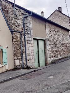 a brick building with a green door on a street at La Mansarde in Vernon