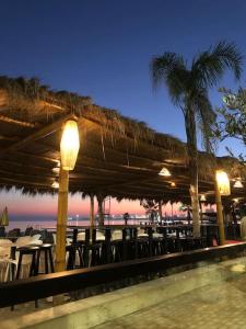 a restaurant with tables and chairs on the beach at night at Sea View Deluxe Apartment in Durrës