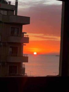 a building with the sunset in the background at Sea View Deluxe Apartment in Durrës