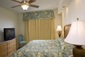 Schlafzimmer mit einem Bett, einem TV und einem Deckenventilator in der Unterkunft Ft Lauderdale Beach resort in Fort Lauderdale