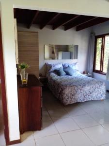 een slaapkamer met een bed en een spiegel aan de muur bij Sol da Pipa Flats Bosque da Praia in Pipa