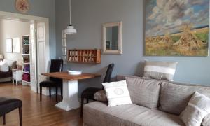 a living room with a couch and a table at LoggiaHaus am Schloss, 5 Ferienwohnungen, teils mit Schloss- und Seeblick in Rheinsberg