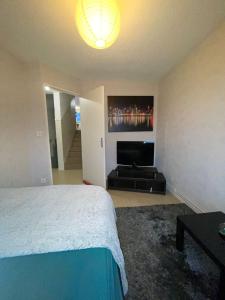 a bedroom with a bed and a flat screen tv at Chambre privée in Clermont-Ferrand
