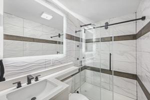 uma casa de banho com um chuveiro, um WC e um lavatório. em Hotel OPUS Bronx Near Bay Plaza Mall em Bronx