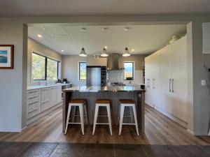 a kitchen with a large island with bar stools at Manakau Lodge in Kaikoura