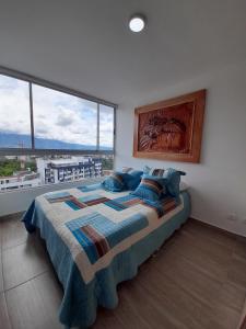 ein Schlafzimmer mit einem großen Bett und einem großen Fenster in der Unterkunft Aparta Estudios zona 10 in Armenia