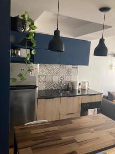 uma cozinha com armários azuis e uma mesa de madeira em Único y Confortable Departamento zona Güemes (La Isla) em Mar del Plata