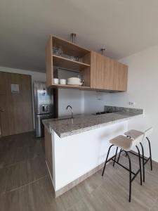 eine Küche mit einer Theke und Hockern in einem Zimmer in der Unterkunft Aparta Estudios zona 10 in Armenia