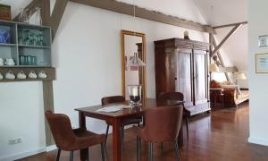 a dining room with a wooden table and chairs at LoggiaHaus am Schloss, 5 Ferienwohnungen, teils mit Schloss- und Seeblick in Rheinsberg