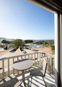 a balcony with a table and chairs and a view of the beach at Fabrikas in Mýkonos City