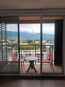 d'une table et de chaises sur un balcon avec vue. dans l'établissement Aparta Estudios zona 10, à Armenia