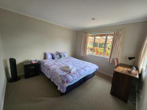 a bedroom with a bed and a window at Sweet home in Albany in Auckland