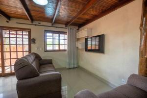a living room with two couches and two windows at LUAR DO MIRANTE ,casa com AR p temporada piscina aquecida hidro dentro da cidade in Pirenópolis