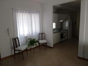 sala de estar con 2 sillas y cocina en Hermoso Departamento en Mendoza en Mendoza
