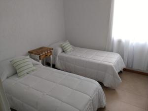 1 dormitorio con 2 camas, mesa y ventana en Hermoso Departamento en Mendoza en Mendoza