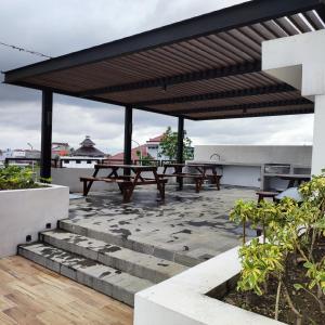 d'une terrasse sur le toit avec des bancs et des tables de pique-nique. dans l'établissement Apartemen Strategis Yogyakarta, à Seturan