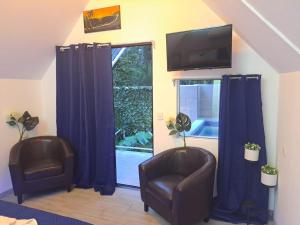 sala de estar con 2 sillas y TV en HOTEL, VILLAS y GLAMPINGS MYA -PUERTO VIEJO, Limon, CR en Puerto Viejo