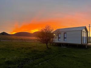 a small white house in a field with a sunset at Villa Pancha del Lunarejo in Sierra de Lunarejo