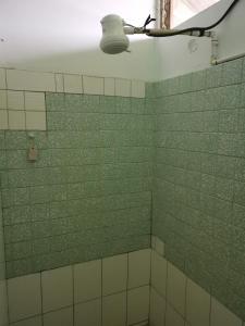 a bathroom with green and white tiled walls and a light at Adorable 2-bedroom stay with Balcony in Almirante