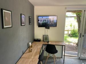 a room with a desk and a tv on a wall at Villa Pancha del Lunarejo in Sierra de Lunarejo