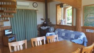 a living room with a table and chairs and a couch at Lassy Condominium in Kumamoto