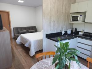 uma cozinha e um quarto com uma cama e uma mesa em Hospedaria Mitterer em Treze Tílias