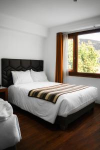 um quarto com uma cama grande e uma janela em Hotel Andes de Urubamba em Urubamba