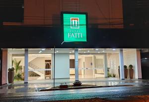a store front with a sign that reads toilet faith at Hotel Fatti in Maringá