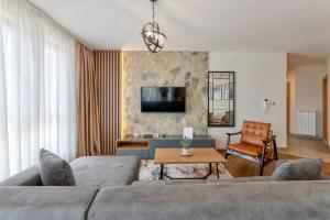 ein Wohnzimmer mit Sofa und Tisch in der Unterkunft Apartmani Stella in Zlatibor + 23 Fotos