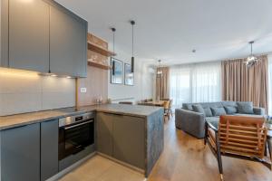 eine Küche und ein Wohnzimmer mit einer Couch und einem Tisch in der Unterkunft Apartmani Stella in Zlatibor