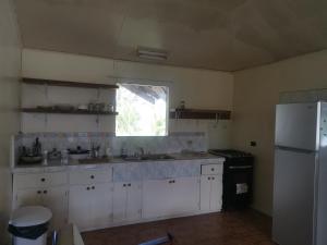 a kitchen with white cabinets and a window and a refrigerator at Adorable 2-bedroom stay with Balcony in Almirante
