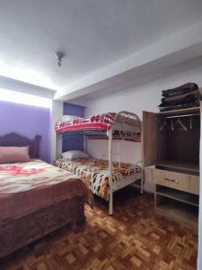 a bedroom with two bunk beds and a wooden floor at Hospedaje de la cuba in Cusco