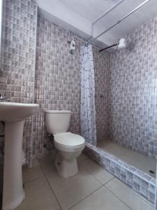 La salle de bains est pourvue de toilettes et d'un lavabo. dans l'établissement Hospedaje de la cuba, à Cusco