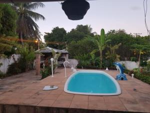 a swimming pool in a backyard with a blue tub at Casa Ilha de Itaparica in Itaparica Town