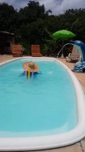 a person in a hat in a swimming pool at Casa Ilha de Itaparica in Itaparica Town