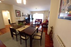 a dining room and living room with a table and chairs at Apartamento Puente Colgante in Getxo