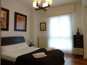a bedroom with a large bed with two towels on it at Apartamento Puente Colgante in Getxo