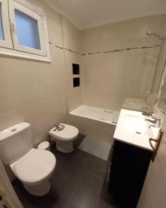 a white bathroom with a toilet and a sink at Apartamento Puente Colgante in Getxo