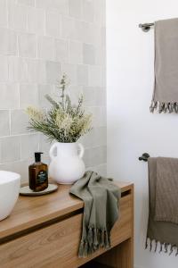 a bathroom with a white vase on a wooden counter at Upland Farm Luxury Cabins, Denmark Western Australia in Denmark