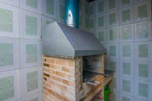 un horno de ladrillo en una habitación con pared en Barlavento Villas en Ilhabela