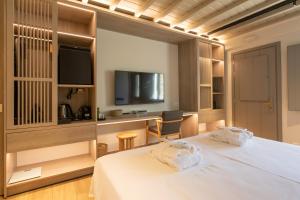 a hotel room with a bed and a tv at Fabrikas in Mýkonos City