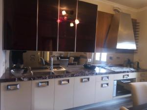 una cocina con armarios blancos y electrodomésticos de acero inoxidable en Bercos deluxe, en Prato